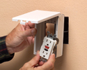 person mounting low profile cover to electrical box then attaching outlet