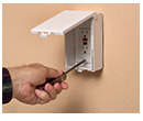 person installing decor style outlet plate in low profile in and out cover