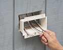 person installing box extender into recessed electrical box