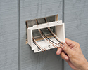 person installing box extender into recessed electrical box