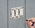 person installing receptacle into electrical box with box extender