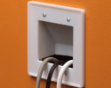 cable entrance plate mounted on wall with three cables run into it
