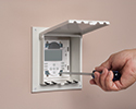 person installing keypad in exterior keypad enclosure