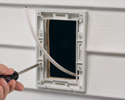 person installing in-box siding profile to house siding with screwdriver