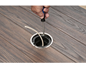 person installing floor box into mounting bracket with screwdriver