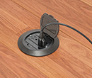 floor box in wooden floor with device plugged in