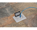 floor box in tiled floor with device plugged in