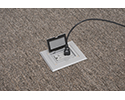 floor box in carpeted floor with device plugged in