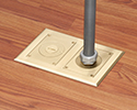 two gang floor box in wooden floor with connector and conduit attached