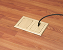 two gang floor box in wooden floor with device plugged in