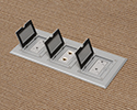 three gang floor box in carpeted floor with flip lids open