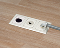 three gang floor box in wooden floor with 90 degree connector and conduit attached