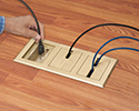 person plugging device into floor box receptacle