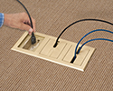 person plugging device into floor box receptacle