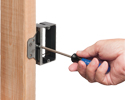 person adjusting depth of mounting bracket on wooden stud with screwdriver