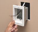 person installing TV box in wall