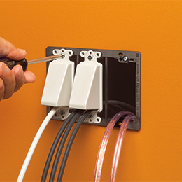 Three gang low voltage mount with wires poking through with two SCOOPs mounted