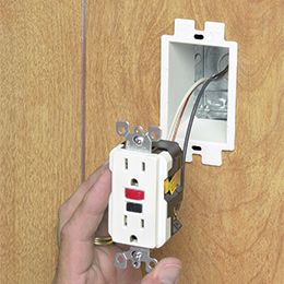 One gang box extender in an outlet box as an outlet is about to be installed